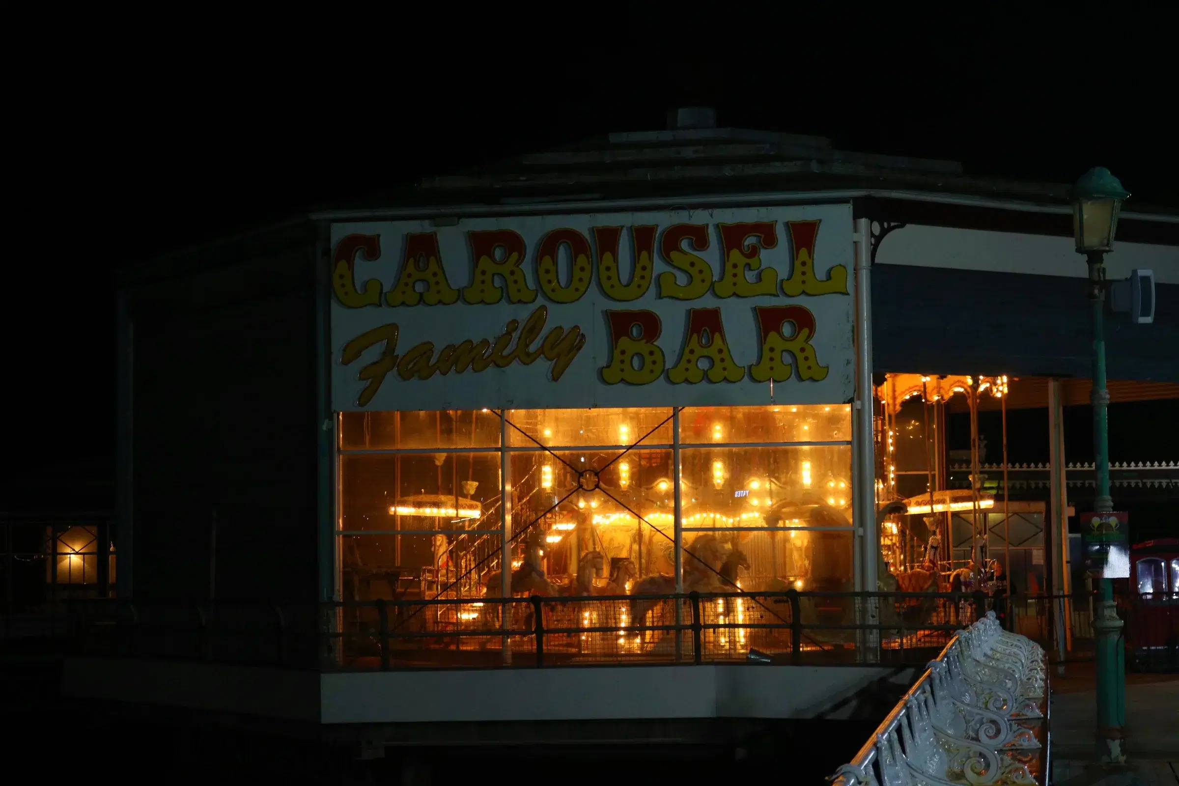 The warmly lit Carousel Family Bar on North Pier at night