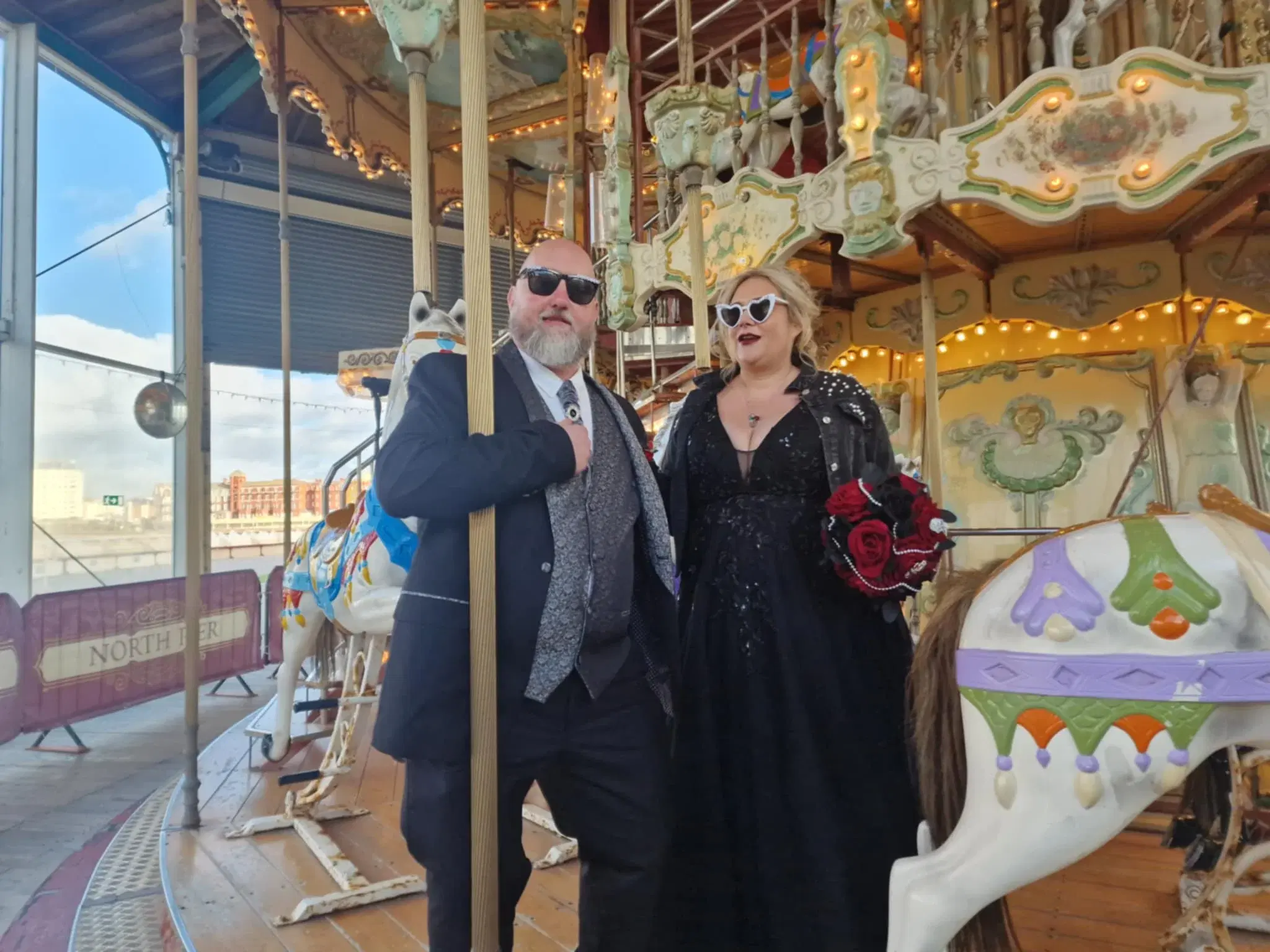 A wedding couple beside the carousel on North Pier