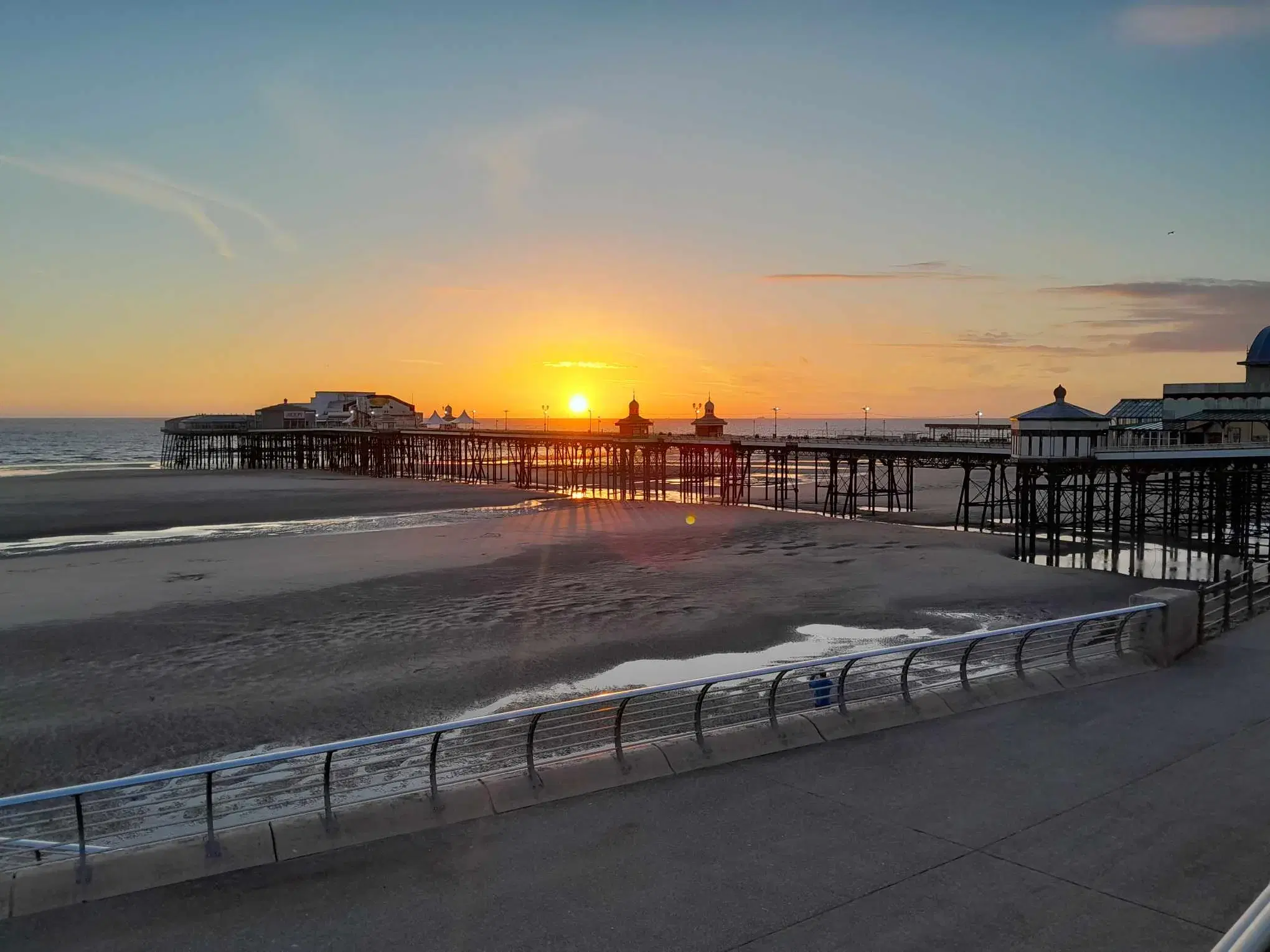 North Pier silhouetted against the setting sun from Blackpool Promenade