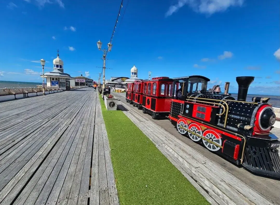 The red land train standing on North Pier under a bright blue sky