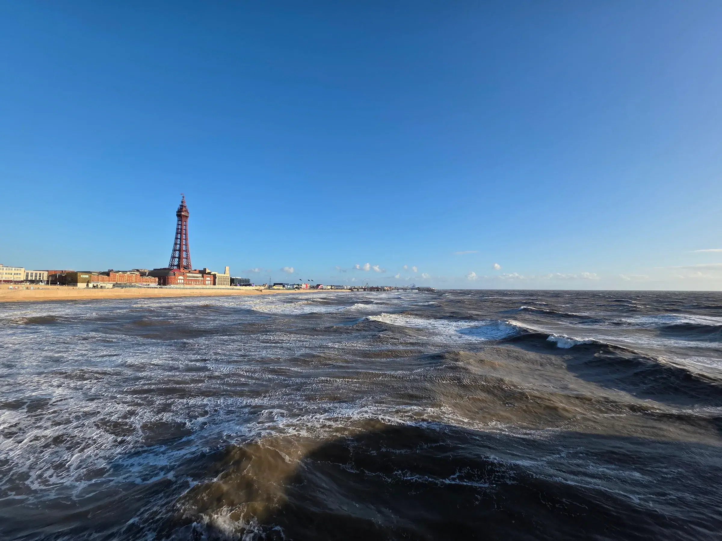 Blackpool Tower seen across a lively sea from North Pier
